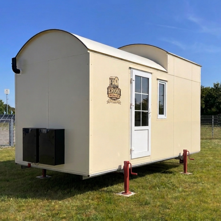 Einfarbiges Tiny House mit schwarzen Kästen an Stirnseite und schwarzem Schornstein auf vier roten Stützen.