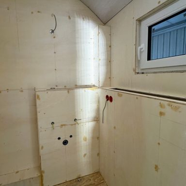 Mit Sperrholz verkleidete Wände und Vorwandkästen im Bad.