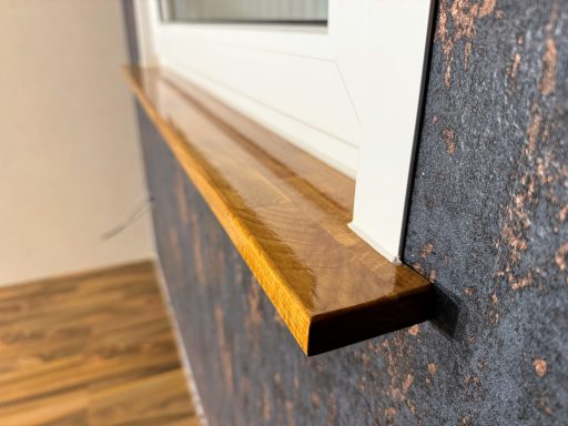 Nahaufnahme Holzfensterbrett und dunkelblauer Tapete.