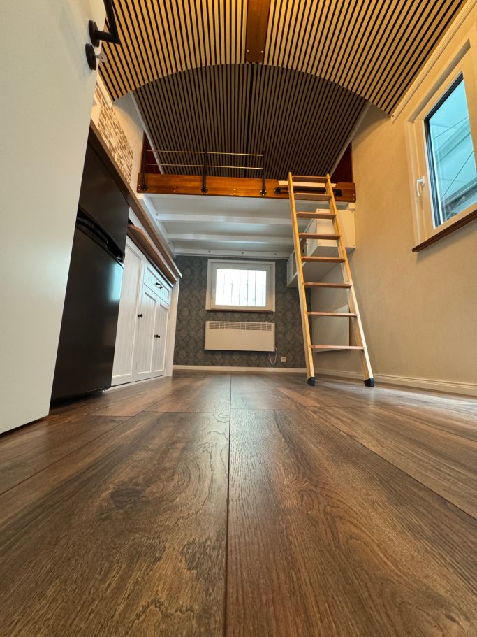 Innenansicht kleineres Tiny House vom Boden Richtung Leiter.