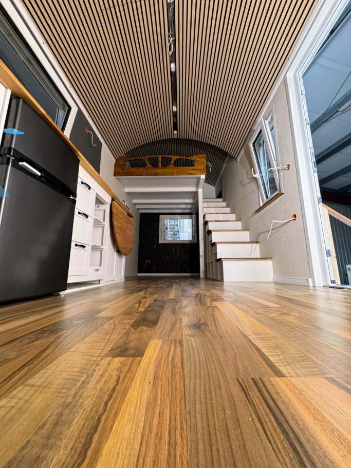 Innenansicht größeres Tiny House vom Boden Richtung Treppe.