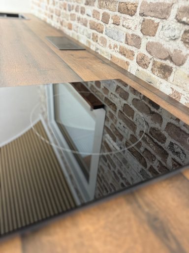 Nahaufnahme Induktionskochfeld, das Fenster spiegelt sich darin.